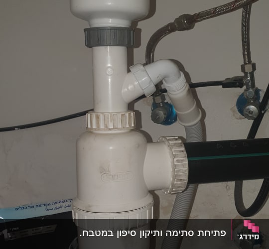 צנרת פלסטיק מתחת לכיור עם מחברים וברזים